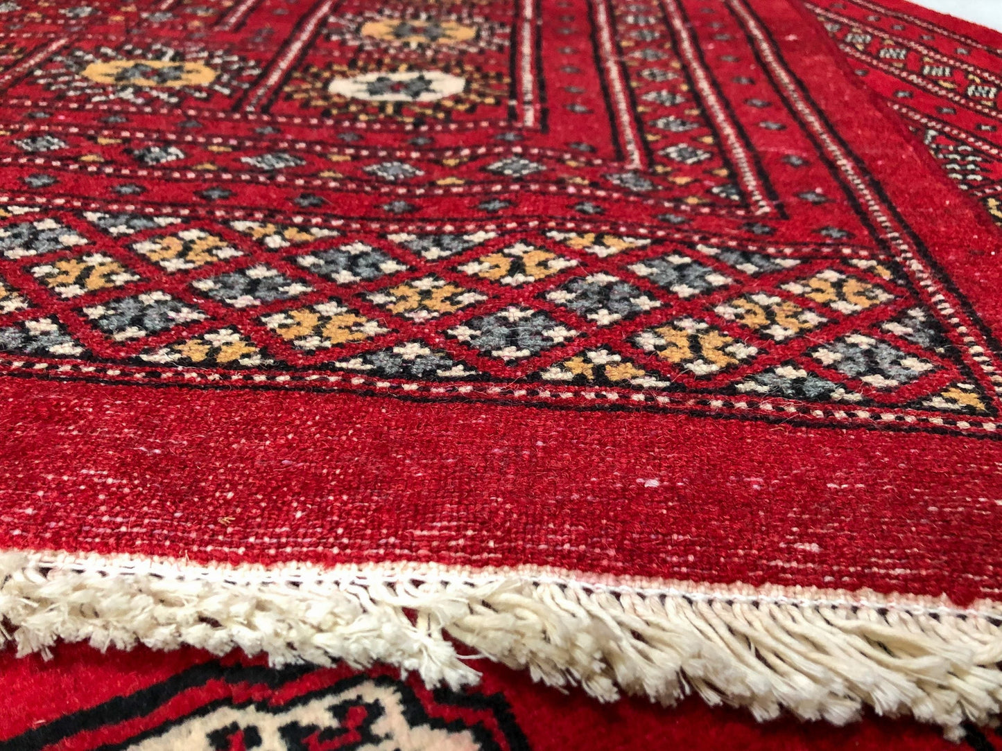 Details of the bottom and edging of the Bokhara (9x12) red area rug
